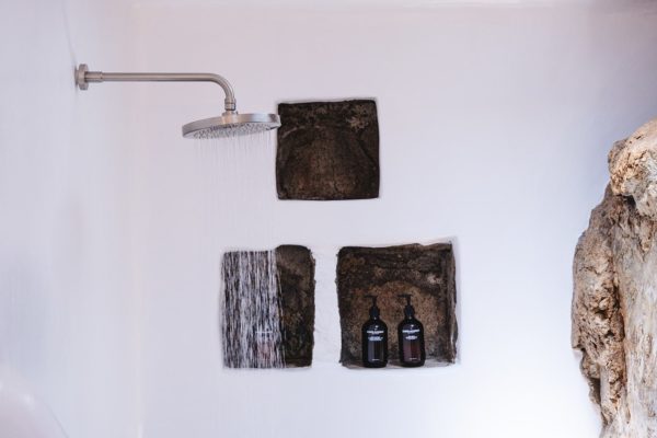 Keli Serifos shower with natural rock and Grown Alchemist toiletries
